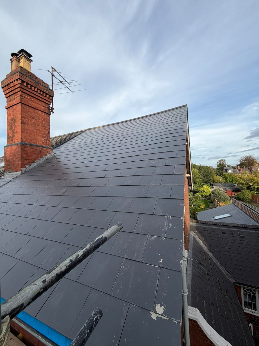 Finished new slate roof next to a brick chimney stack in Kidderminster
